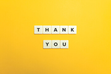 Thank You. Block letter tiles on bright orange background.