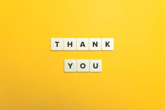Thank You. Block letter tiles on bright orange background.