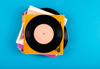 A stack of vinyl records on a blue background.Top view.