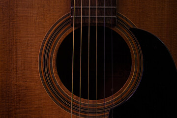 acoustic guitar closeup.Guitar.Guitar's chords.Acoustic guitar.Music.Music background.Image of an acoustic guitar in the dark.Playing music with some friends in the dark.Classical music.Guitar closeup