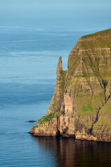 Trollkonufingur - a rock pillar rising from the sea at the coast of Vagar island, the Faroe Islands. View from Sornfelli ridge, Streymoy.