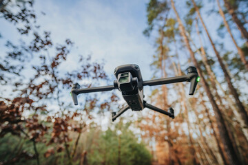 Flying drone in countryside in forest