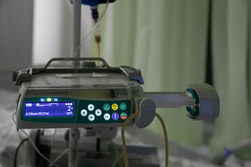 Infusion pump attached to a drip rack. A syringe filled with medicine is installed into the...