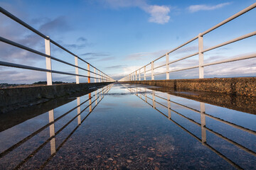 reflet des garde- corps dans une flaque d' eau sur un pont