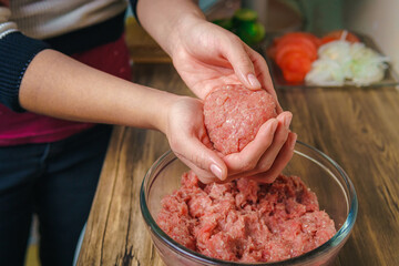 Young woman preparing ground beef for hamburgers
