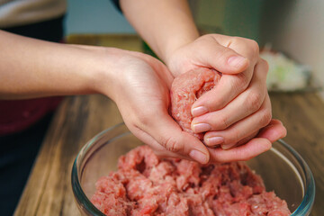 Young woman preparing ground beef for hamburgers