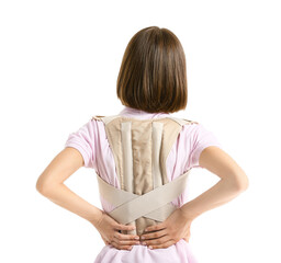 Young woman in back brace on white background