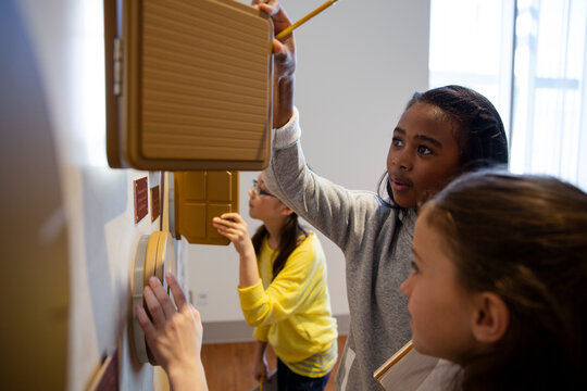 Students examining clock exhibit at science center