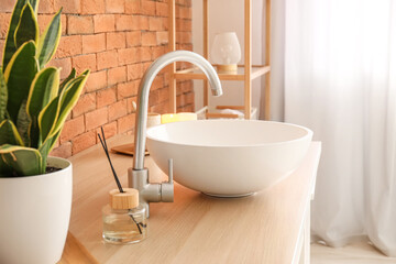 Naklejka na ściany i meble Table with sink and reed diffuser near brick wall