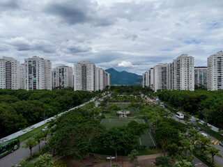 Obraz na płótnie Canvas Aerial view of Cidade Jardim, in Jacarépagua in Rio de Janeiro, Brazil. Residential buildings and mountains in the background. Cloudy day. Drone photo