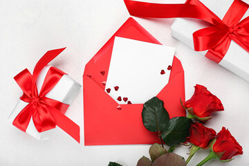 Beautiful roses, envelope with letter and gift boxes for Valentine's Day on light background