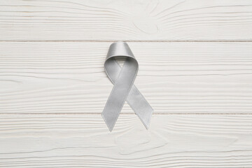 Parkinson's awareness ribbon on white wooden background