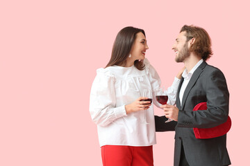 Happy young couple with wine and gift on color background. Valentine's Day celebration