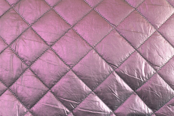 Pink chameleon raincoat fabric quilted with a diamond. Pink mother-of-pearl background