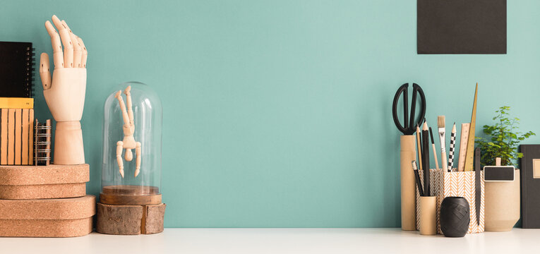 Creative Desk With A Picture Frame Or Poster Space, Desk Objects, Office Supplies, Books, And Plant On A Pastel Green Background.	