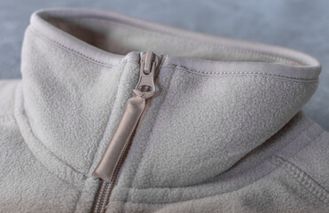 Close-up of a beige fleece jacket with a fastener. Item of clothing © IrynaOpalinska