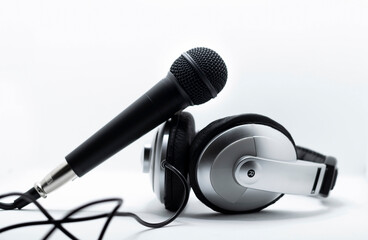 Isolated black microphone and silver headphones from the front view with white background 