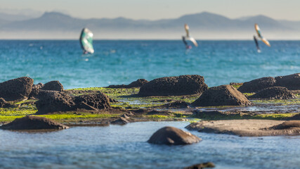 Scenic view of the sea and wing foil surfers in the background