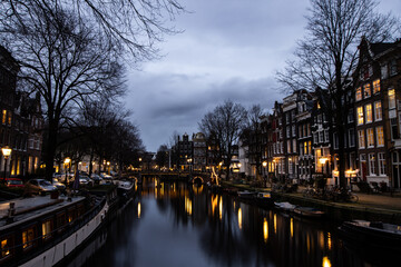 Fototapeta na wymiar Amsterdam at night with canal and buildings. Lights in winter
