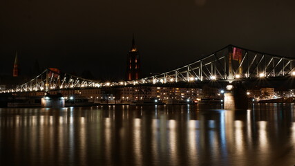 Der berühmte Eiserne Steg in Frankfurt am Main bei Nacht mit dem Kaiserdom, der auf der Brücke zu schweben scheint