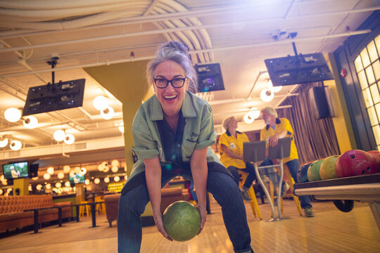 Woman Bowling Between Legs At Bowling Alley