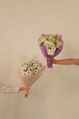 two white bouquets in hands