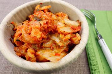 Spicy Ready to Eat Kimchi in a Round Wooden Bowl Close-up