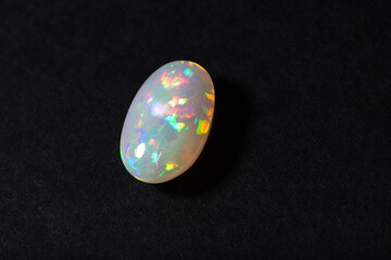 Colorful milky opal gem from Welo Ethiopia on black background