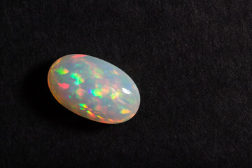 Colorful milky opal gem from Welo Ethiopia on black background