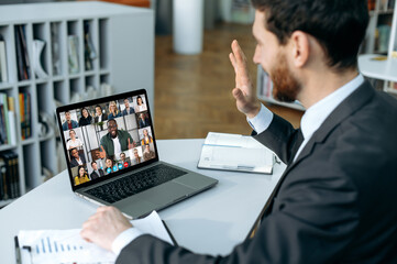 Successful man using a laptop, conducts virtual meeting with business partners on a video call....