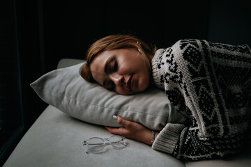 woman sleeping on sofa in winter morning