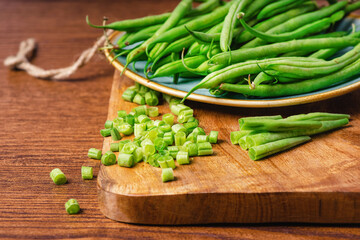 Whole and chopped fresh green beans on a cutting board.Bowl of green beans .Fresh Asparagus Beans For Eating.Salad ,Wooden Background ,Spinach Salad ,Healthy Fresh Food.Healthy and fresh food.
