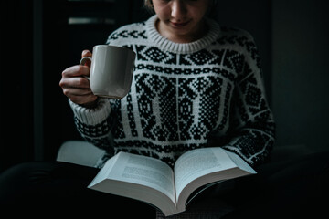 woman reading a book while drinking coffee