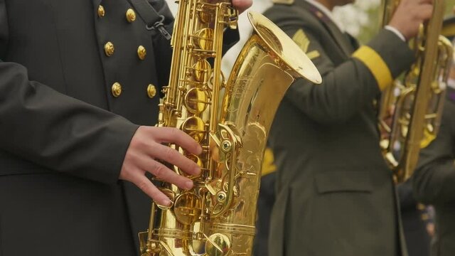 Close up video shot of a military band member saxophone playing person on the celebrations of republic day of Turkey 29 October 2021 and the other music playing people on the defocused background