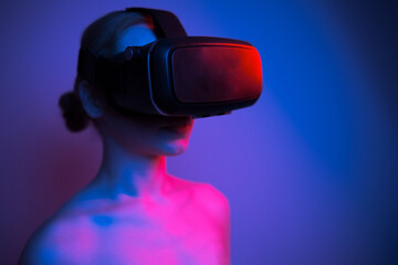 woman in vr glasses stretching her finger to touch something in virtual world