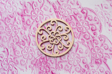 fancy wooden object and its print in pink on paper