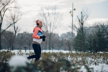 Woman running in the park on a cold winter day.