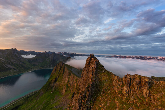 Scenic views of the mountains and fjords. The rocks are lit by the sun. Beautiful white clouds in the morning light. Panoramic view. Dawn. Norway. Northern nature. Scandinavia.