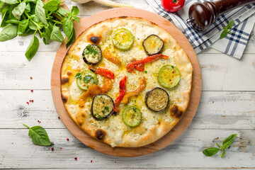 Pizza with vegetables and cheese, vegetarian pizza on the board top view on white wooden table