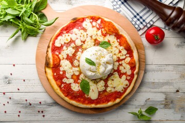 Pizza with burrata cheese, tomato sauce and basil top view on white wooden table