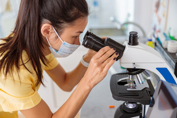 Female vet assistant examining biomaterial in laboratory