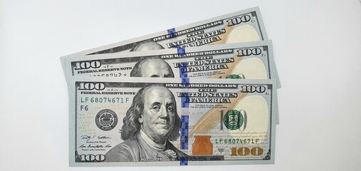 New one hundred dollar bills. Three hundred dollars on the table.