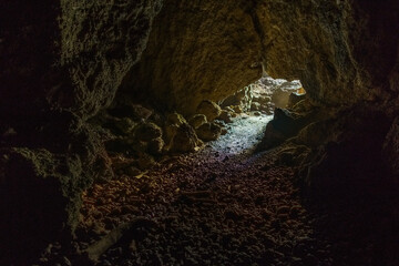 light falling through entrance of a cave falling on stone walls