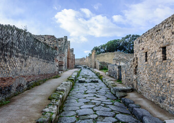 Roman stone paved street and the ruined buildings of the ancient Roman city of Pompeii, Italy