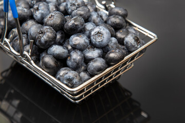 Fresh blueberries in a grocery basket on a background with a mirror image. vitamin food for health