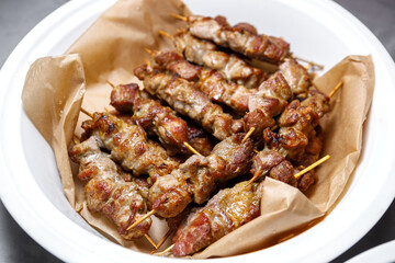 Meat kebab on a wooden skewer on a plate.
