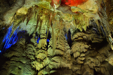 Prometheus cave formations in Georgia. Limestone stalactites and stalagmites in colourful illumination. Underground world of caucasian mountains