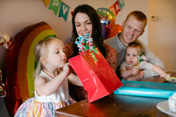 A Young Girl Peeks into a Gift Bag on Her Birthday