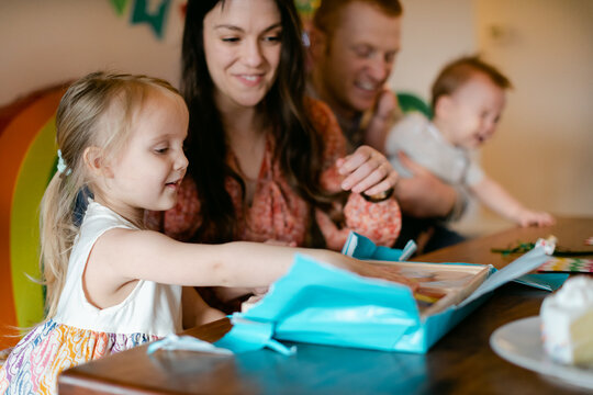 Young Girl Unwrapping Presents on Her Birthday