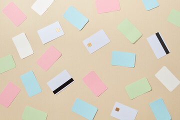 Colorful bank cards scattered on beige background